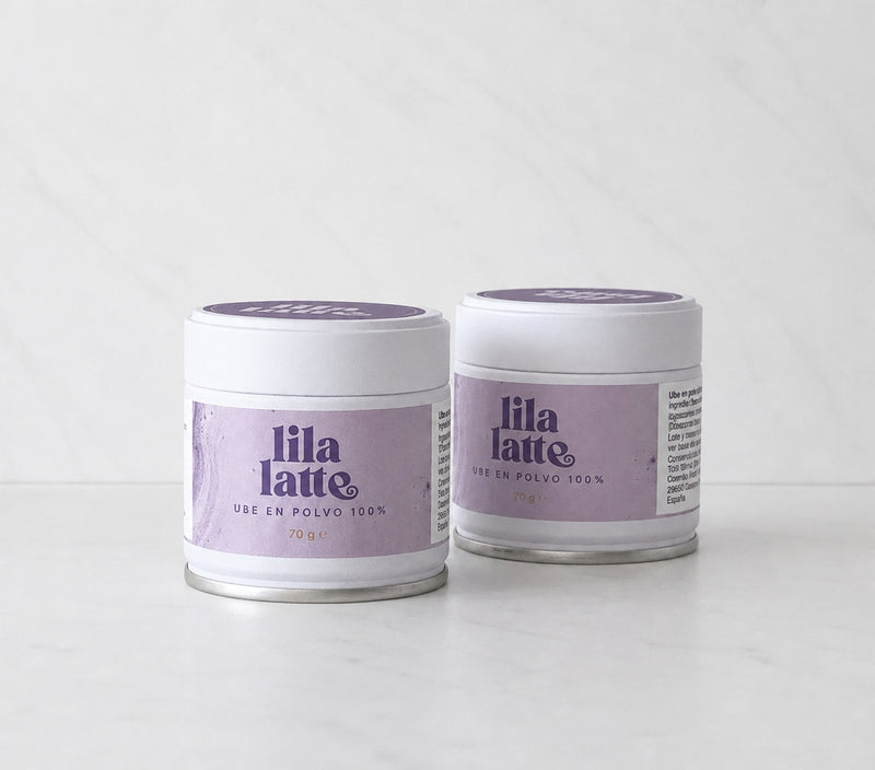 Pack de dos latas de Lila Latte sobre mármol blanco