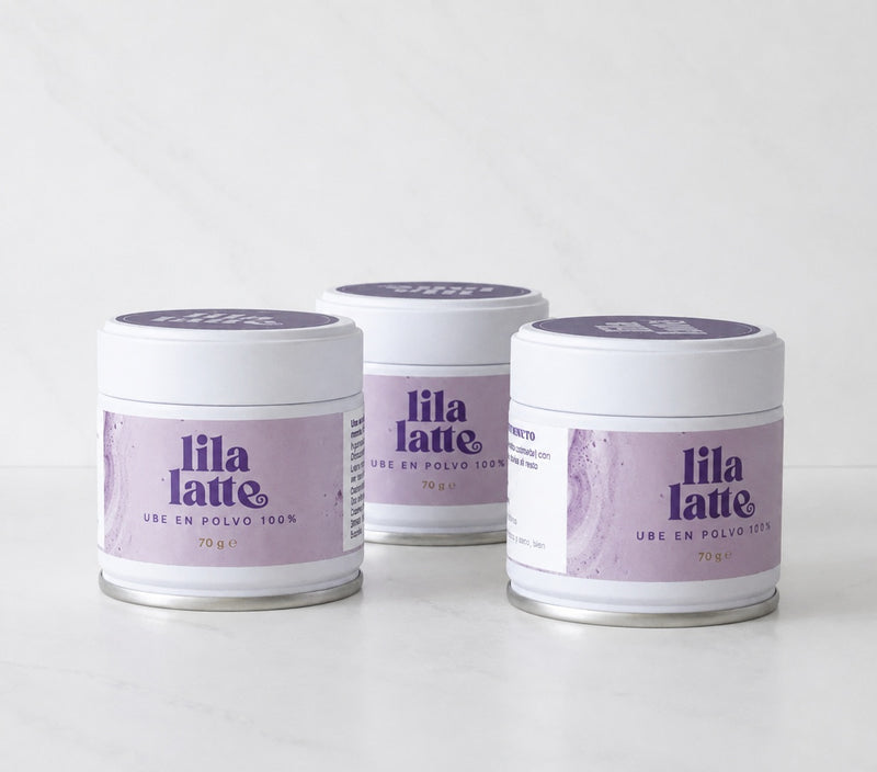 Pack de tres latas de Lila Latte sobre mármol blanco
